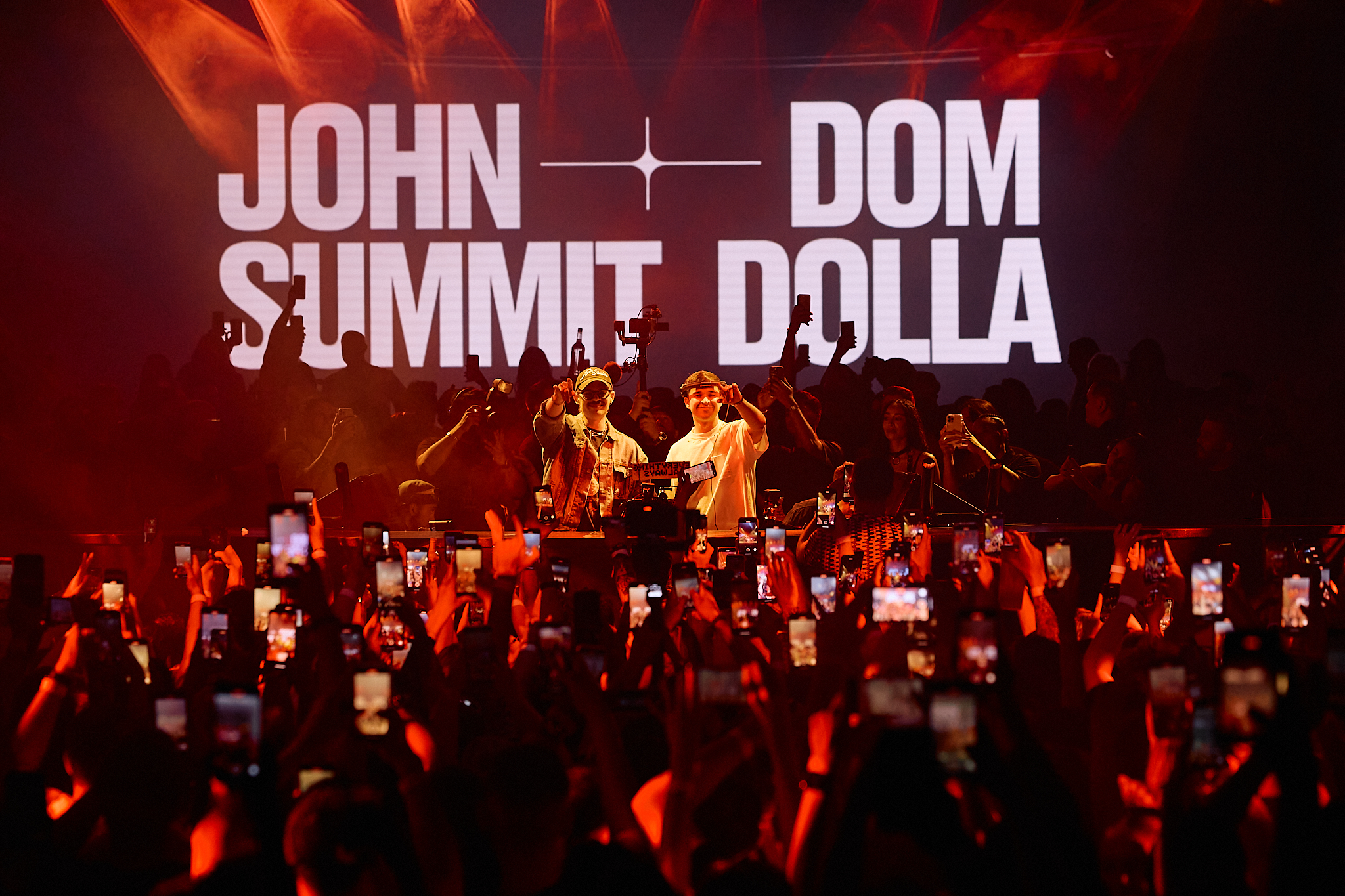 Crowd angle of Dom Dolla and John Summit pointing at crowd with their names on the LED screen behind them