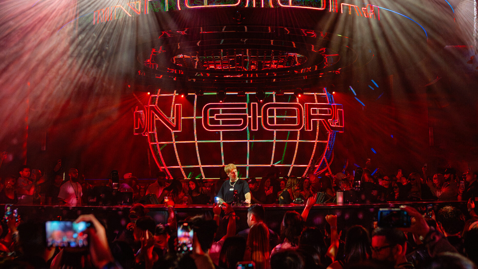 Layton Giordani behind the DJ booth, in front of a packed crowd.