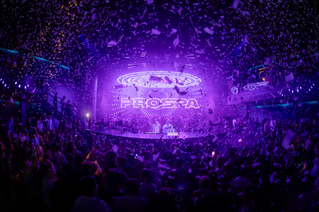 Prospa performing at LIV Las Vegas with confetti and purple lighting above packed crowd.