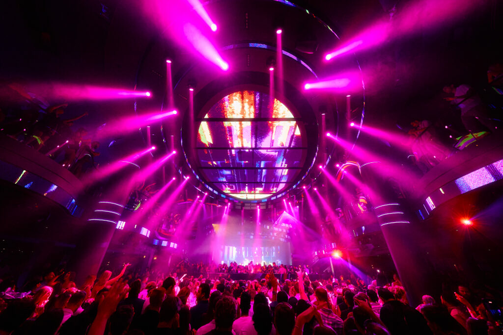 Packed LIV Las Vegas dance floor under vibrant pink lighting and circular LED ceiling display.
