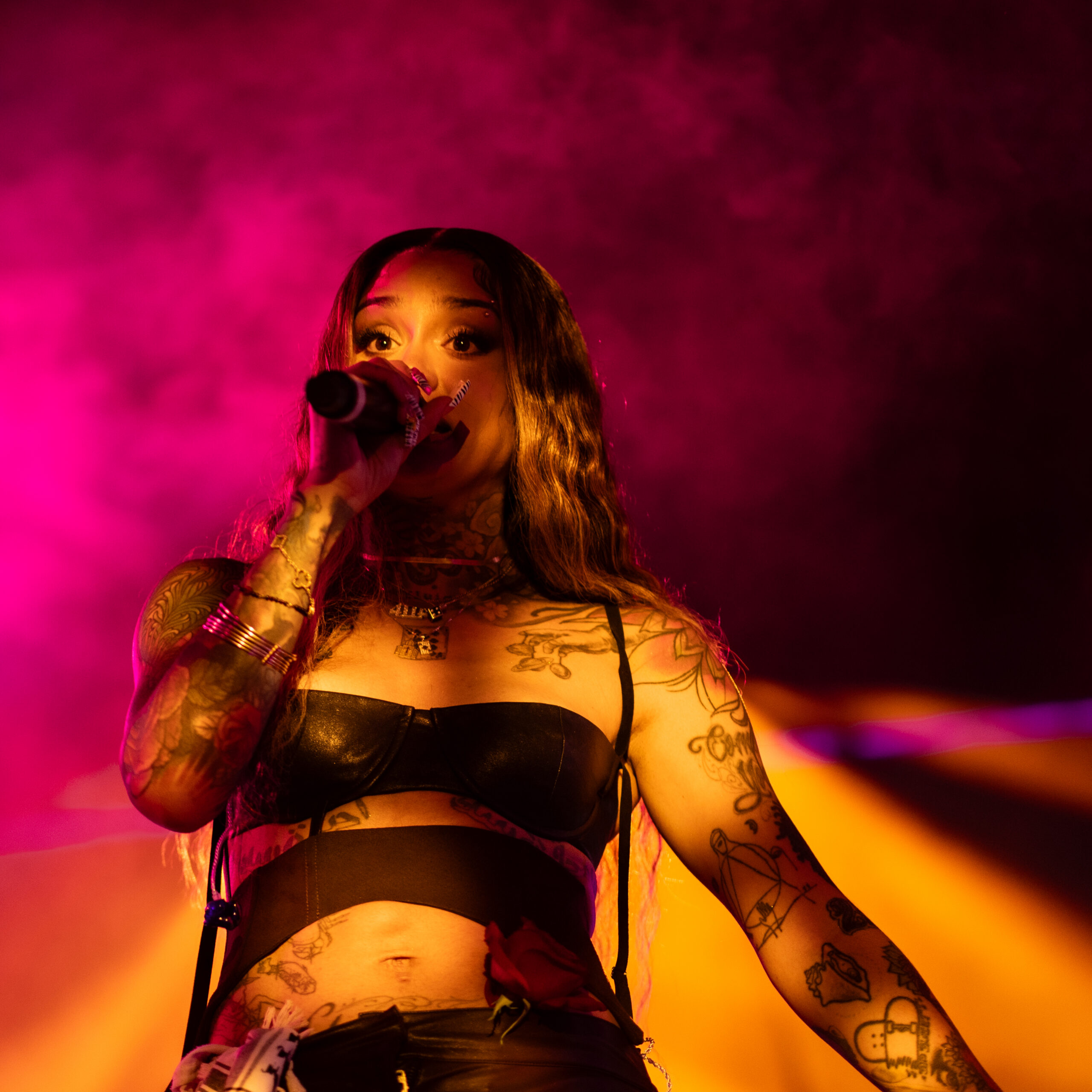 Kehlani singing to the crowd, holding a microphone to her face. 