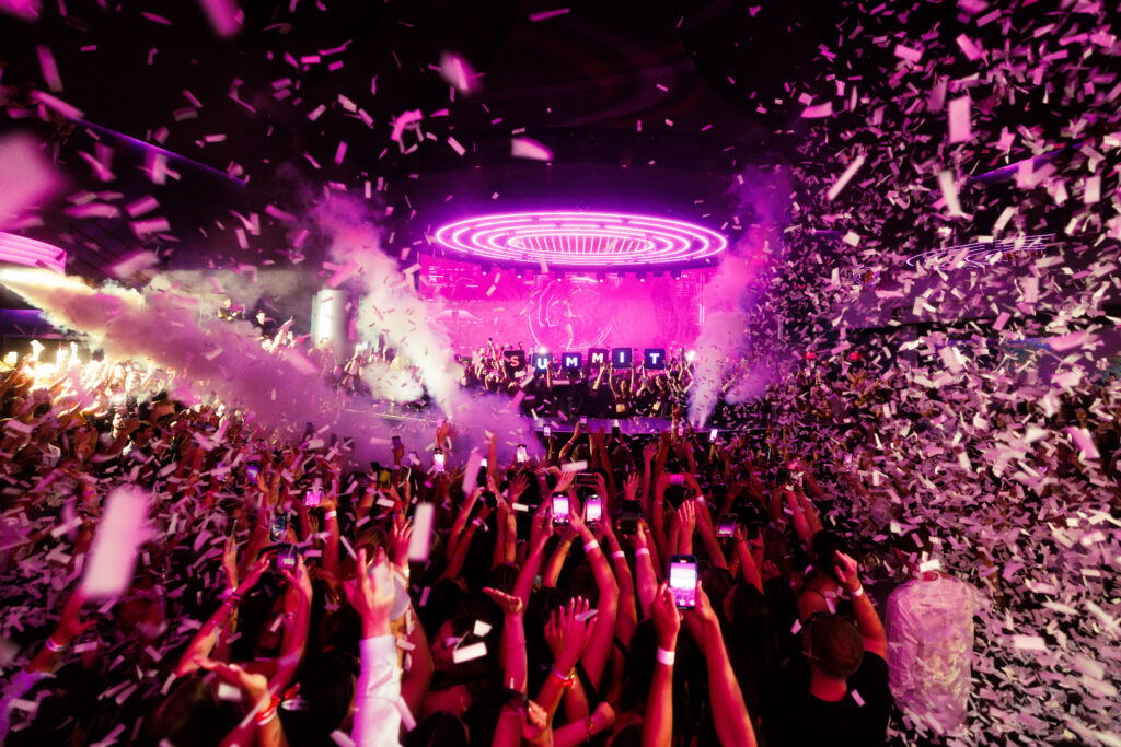 An energetic crowd at LIV Las Vegas watching John Summit and surrounded by confetti.
