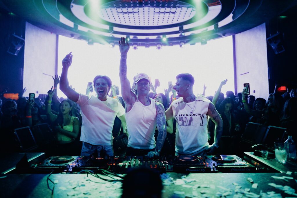 Josh Baker, Kettama, and Prospa dancing at the DJ booth.