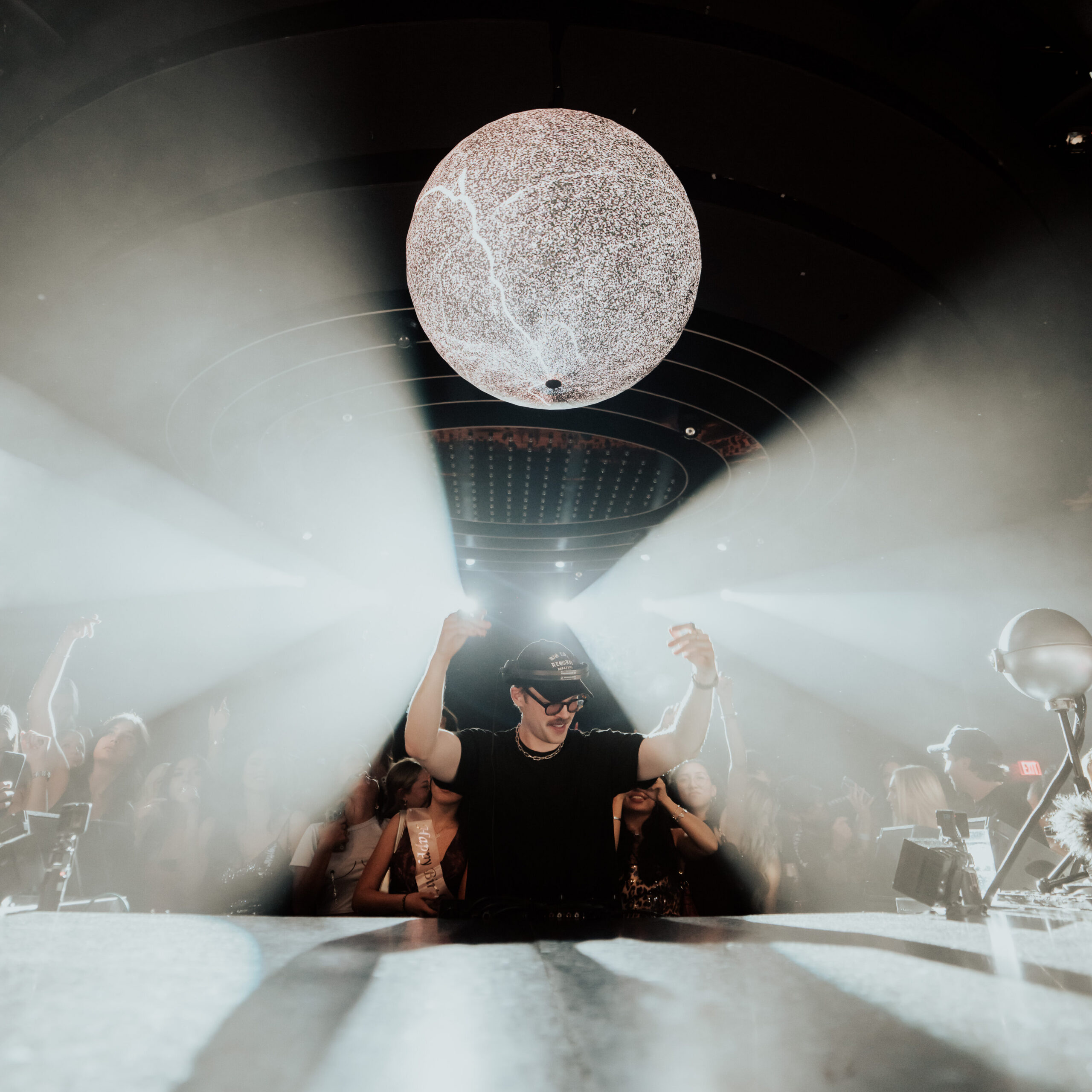 Dom Dolla dancing beneath his signature orb at the LIV Las Vegas DJ booth.